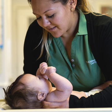 Careers Content Page teacher laying infant down